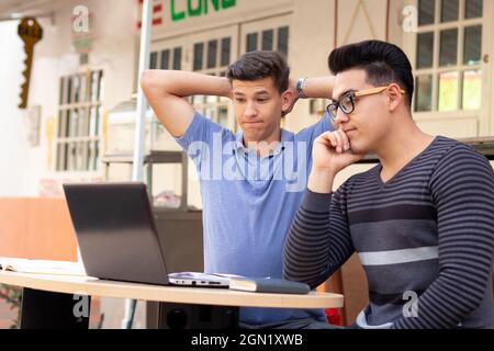 Two men saddened by something they see on the laptop Stock Photo