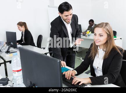 Bearded man flirting with woman working in office Stock Photo