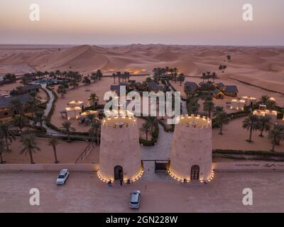 Aerial view from entrance to Arabian Nights Village desert resort amidst dunes at sunset, Arabian Nights Village, Razeen Area of Al Khatim, Abu Dhabi, Stock Photo
