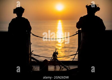 STRAIT OF HORMUZ (Sept. 17, 2021) Marine Corps Cpl. Noah Verrill, left, and Cpl. Fausto Reyes, both team leaders assigned to Alpha Company, Battalion Landing Team 1/1, 11th Marine Expeditionary Unit (MEU), stand guard during the Strait of Hormuz transit aboard amphibious transport dock USS Portland (LPD 27). Portland and the 11th MEU are deployed to the U.S. 5th Fleet area of operations in support of naval operations to ensure maritime stability and security in the Central Region, connecting the Mediterranean and Pacific through the Western Indian Ocean and three strategic choke points. (U.S. Stock Photo