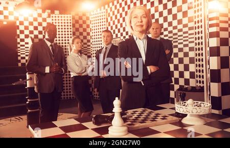 Toned image of confident business woman on background with team Stock Photo