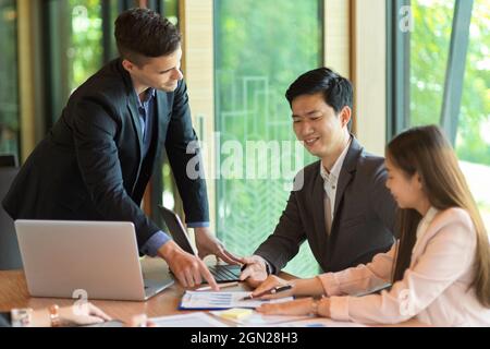 Group of business members conversing and discussing on financial data graph report in meeting room Stock Photo