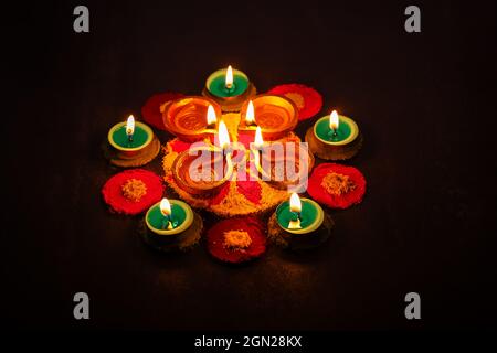 Diwali celebration Indian festival of lights Diya oil lamp and colors Rangoli decoration bright colorful flowers flowerbed copy space Deepavali Stock Photo