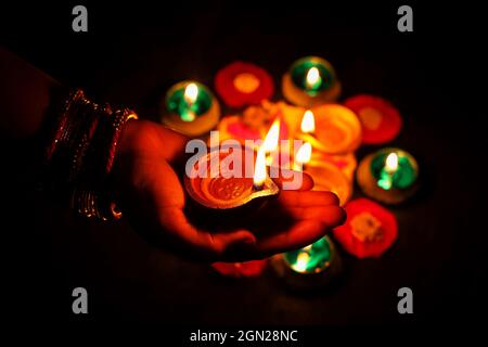 Diwali celebration Indian festival of lights Diya oil lamp and colors Rangoli decoration bright colorful flowers flowerbed copy space Deepavali Stock Photo