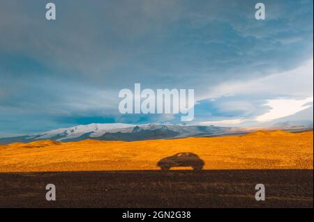 ICELAND, A CAR IN SHADOW ON A ROAD IN ICELAND Stock Photo