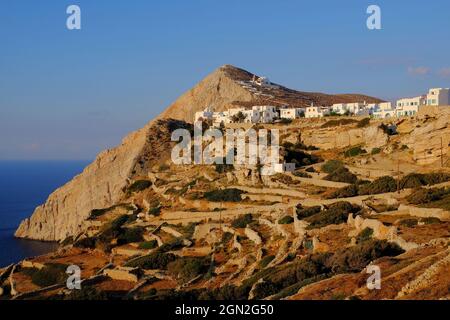 Old terraced slopes, the sea and the Chora soon before sunset on Folegandros Island, Cyclades, Greece Stock Photo