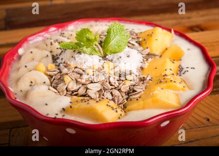 healthy mango bannana smoothie bowl with wooden background Stock Photo
