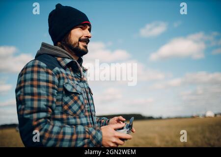 Man pilot controlling quadcopter drone with remote controller pad. Stock Photo