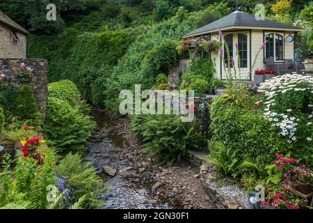 A beautiful cottage garden on the banks of a stream flowing into the River Sett in Hayfield, High Peak, Derbyshire, England, Uk Stock Photo