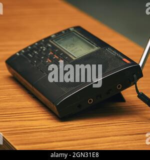 Black analog radio receiver on a wooden table Stock Photo