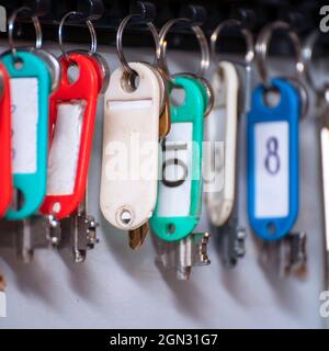 The keys to the doors with tags hang on hooks in a special drawer. Selective focus Stock Photo