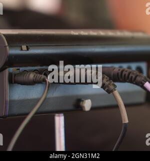 The wires are in a small mixing console. Rear view. Selective Focus Stock Photo
