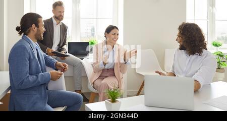 Friendly colleagues who have good relationship have pleasant conversation in office during break. Stock Photo