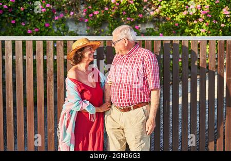 Happy old couple enjoying walk together standing looking at each other Stock Photo