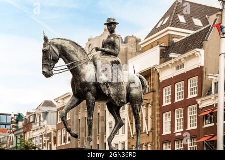 Low angle of bronze Equestrian statue of Queen Wilhelmina against European buildings in Amsterdam Stock Photo