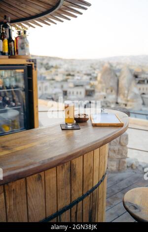 Glass of cold beer with snacks and menu placed on wooden round counter in bar Stock Photo