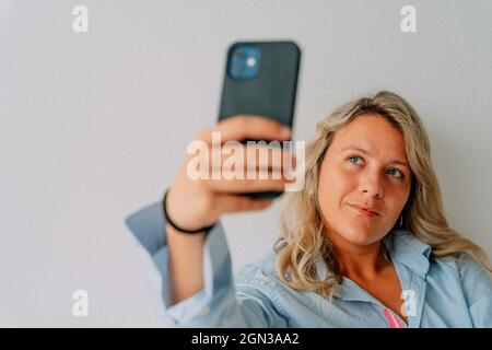 Female doctor wearing medical uniform and mask healing teeth with UV tool while working with colleague in contemporary dental clinic Stock Photo