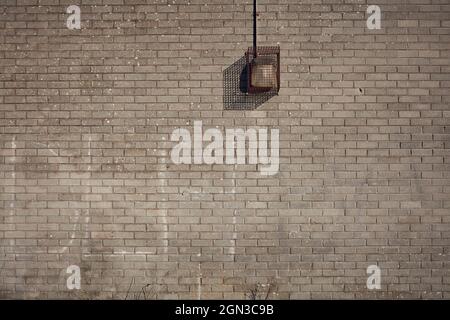 Grey brick wall with vandal proof light Stock Photo