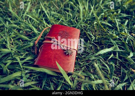 brown leather notebook on a background of green grass Stock Photo
