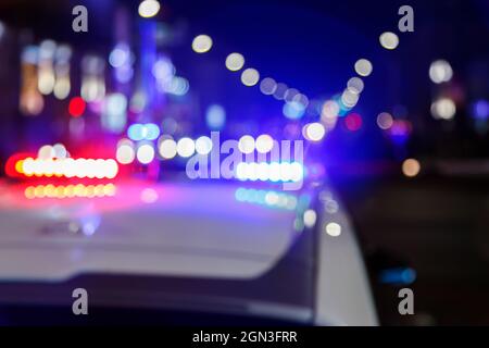 defocused photo of police car lights in night city with selective focus and bokeh Stock Photo