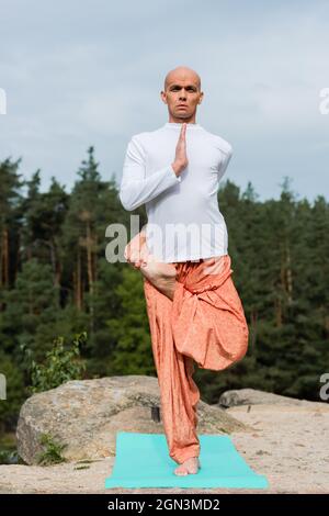 full length view of buddhist in sweatshirt and harem pants