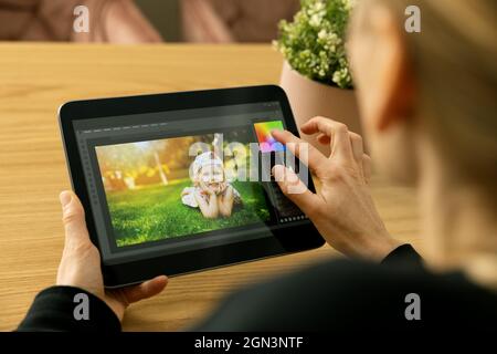woman photographer using photo editing app on digital tablet Stock Photo