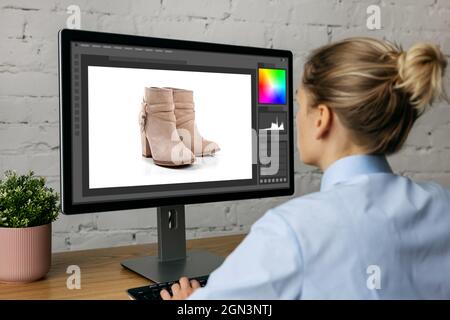 woman doing product photo editing on desktop computer in office Stock Photo