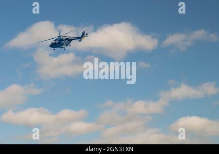 Dhruv, an advanced light helicopter developed by Hindustan Aeronautics Limited's, flies against the backdrop of white puffy clouds. Stock Photo