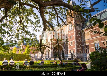 Visitors sit in the garden of the Rijksmueum - the dutch national museum in Amsterdam South, Netherlands, Holland Stock Photo