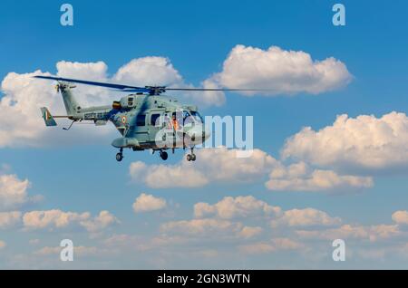 Dhruv, an advanced light helicopter developed by Hindustan Aeronautics Limited's, flies against the backdrop of white puffy clouds. Stock Photo