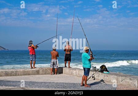 RIO DE JANEIRO, BRAZIL - MARCH 25, 2017: Men fishing at Barra da Tijuca beach pier Stock Photo