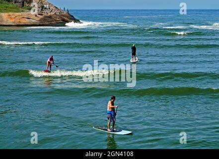 RIO DE JANEIRO, BRAZIL - APRIL 21, 2017: People practicing stand up paddle at Barra da Tijuca beach Stock Photo