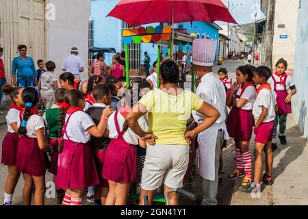 TRINIDAD, CUBA - FEB 8, 2016: Group of Young Pioneer girls and boys at a street food stall in Trinidad, Cuba. Stock Photo