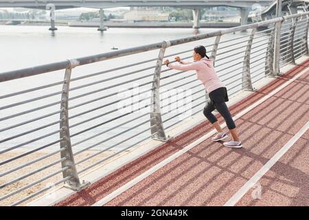 Young woman training on the stadium outdoors with the beautiful view on the sea Stock Photo