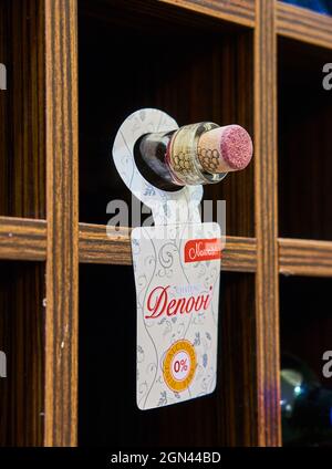 POZNAN, POLAND - Nov 21, 2017: A Denovo alcohol-free red wine in a bottle laying on a wooden shelf. Stock Photo