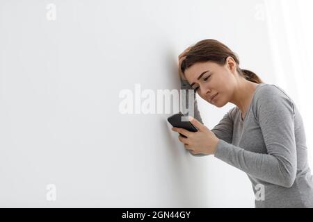 Despair caucasian young attractive woman at home alone, feeling sad, tired and expects call Stock Photo