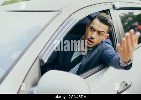 Irritated middle-eastern businessman driving auto, fighting on road Stock Photo