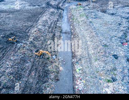 Aerial vie taked with a drone of trash collectors on a garbage deposit, many people live by collecting waste from the mountains of garbage that is generated daily, mostly from the capital of Dhaka.   Bangladesh, the eighth most populous country in the world, currently has a serious pollution problem  due The solid waste generation in urban areas of Bangladesh amounts to around 25,000 tons per day, which translates. The Dhaka city produces one-quarter of all urban waste in the country. The total urban solid waste is projected to grow up to 47,000 tons per day by 2025. On September 22, 2021 in D Stock Photo