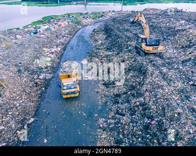 Aerial vie taked with a drone of trash collectors on a garbage deposit, many people live by collecting waste from the mountains of garbage that is generated daily, mostly from the capital of Dhaka.   Bangladesh, the eighth most populous country in the world, currently has a serious pollution problem  due The solid waste generation in urban areas of Bangladesh amounts to around 25,000 tons per day, which translates. The Dhaka city produces one-quarter of all urban waste in the country. The total urban solid waste is projected to grow up to 47,000 tons per day by 2025. On September 22, 2021 in D Stock Photo