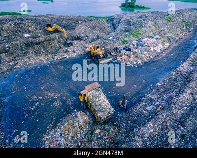 Aerial vie taked with a drone of trash collectors on a garbage deposit, many people live by collecting waste from the mountains of garbage that is generated daily, mostly from the capital of Dhaka.   Bangladesh, the eighth most populous country in the world, currently has a serious pollution problem  due The solid waste generation in urban areas of Bangladesh amounts to around 25,000 tons per day, which translates. The Dhaka city produces one-quarter of all urban waste in the country. The total urban solid waste is projected to grow up to 47,000 tons per day by 2025. On September 22, 2021 in D Stock Photo