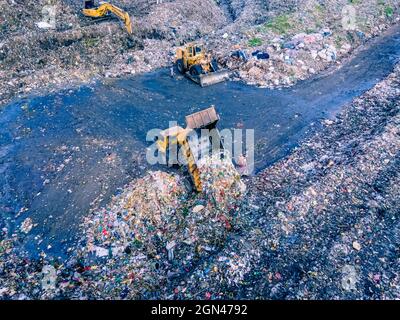 Aerial vie taked with a drone of trash collectors on a garbage deposit, many people live by collecting waste from the mountains of garbage that is generated daily, mostly from the capital of Dhaka.   Bangladesh, the eighth most populous country in the world, currently has a serious pollution problem  due The solid waste generation in urban areas of Bangladesh amounts to around 25,000 tons per day, which translates. The Dhaka city produces one-quarter of all urban waste in the country. The total urban solid waste is projected to grow up to 47,000 tons per day by 2025. On September 22, 2021 in D Stock Photo