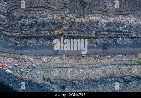 Aerial vie taked with a drone of trash collectors on a garbage deposit, many people live by collecting waste from the mountains of garbage that is generated daily, mostly from the capital of Dhaka.   Bangladesh, the eighth most populous country in the world, currently has a serious pollution problem  due The solid waste generation in urban areas of Bangladesh amounts to around 25,000 tons per day, which translates. The Dhaka city produces one-quarter of all urban waste in the country. The total urban solid waste is projected to grow up to 47,000 tons per day by 2025. On September 22, 2021 in D Stock Photo