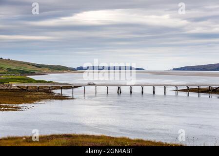 A van crosses the Kyle of Tongue bridge on the A838, part of the  NC500 northern Scotland, with Tongue Bay and Eilean Nan Ron island beyond them. Stock Photo