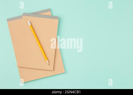 Craft sketchbook with pencil on cyan background Stock Photo