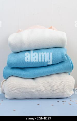 stack of cotton wool sweaters isolated on white and light blue background Stock Photo