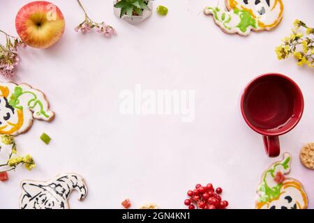 Halloween festive background: red cup, homemade cookies in shape of cute pumpkins and ghost. Atmospheric aesthetic autumn mood or trick or treat concept. Apples, dry flowers, candied fruit. Copy space Stock Photo