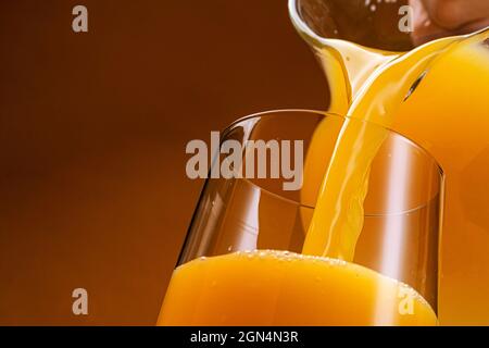 Orange juice pouring into glass  Stock Photo