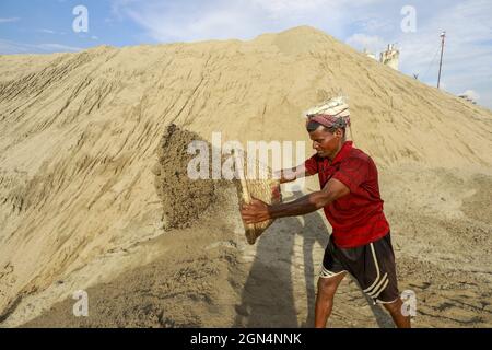 Dhaka, Bangladesh. 22nd Sep, 2021. A Bangladeshi worker unloads sand on the banks of the Buriganga River in Dhaka, Bangladesh, September 22, 2021. (Credit Image: © Suvra Kanti Das/ZUMA Press Wire) Stock Photo