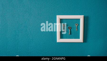 Key in frame on blue wall backgroung. Key new home, homeownership, keys to the house, buying home Stock Photo