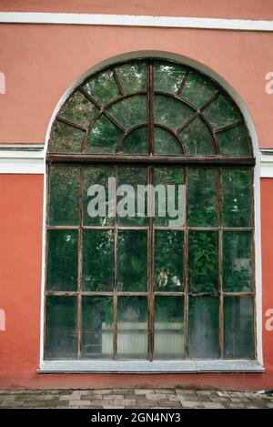 Small pink house with a large arched window Stock Photo